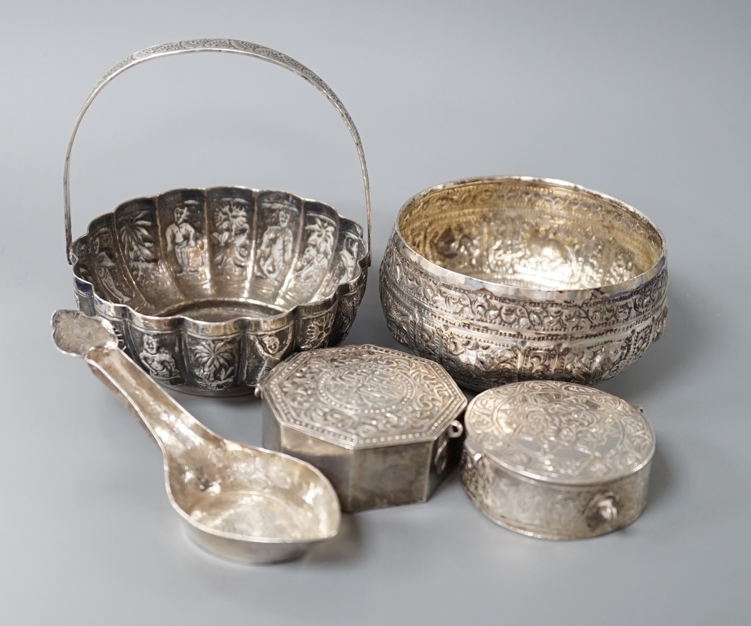 A Burmese? white metal bonbon basket, height 10.1cm and a similar bowl, two Persian white metal boxes and a spoon.